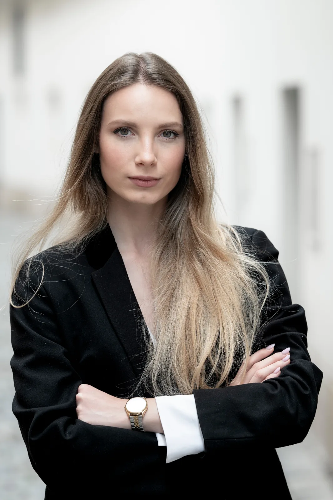 Editorial executive portrait of a female business leader in a black blazer — confident presence in a Vienna street setting, leadership photography Austria