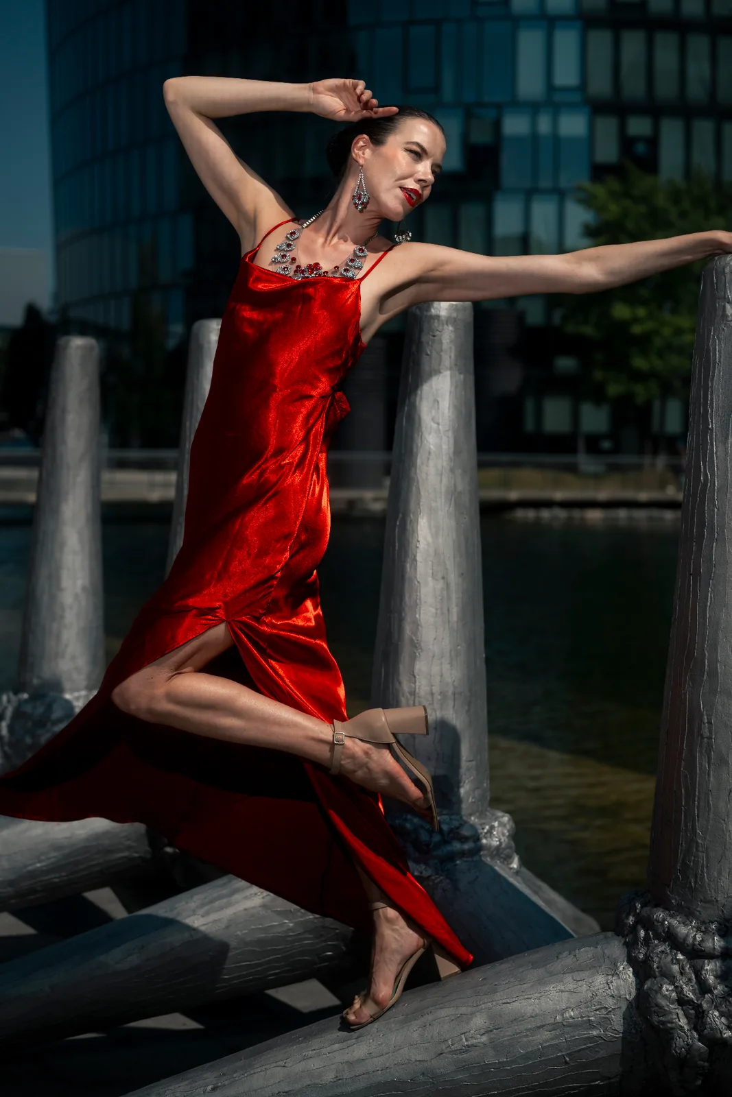 Final frame of the Vienna editorial: model in a red dress against the glass and steel architecture around Messe Wien, lit with a Godox AD200 Pro.
