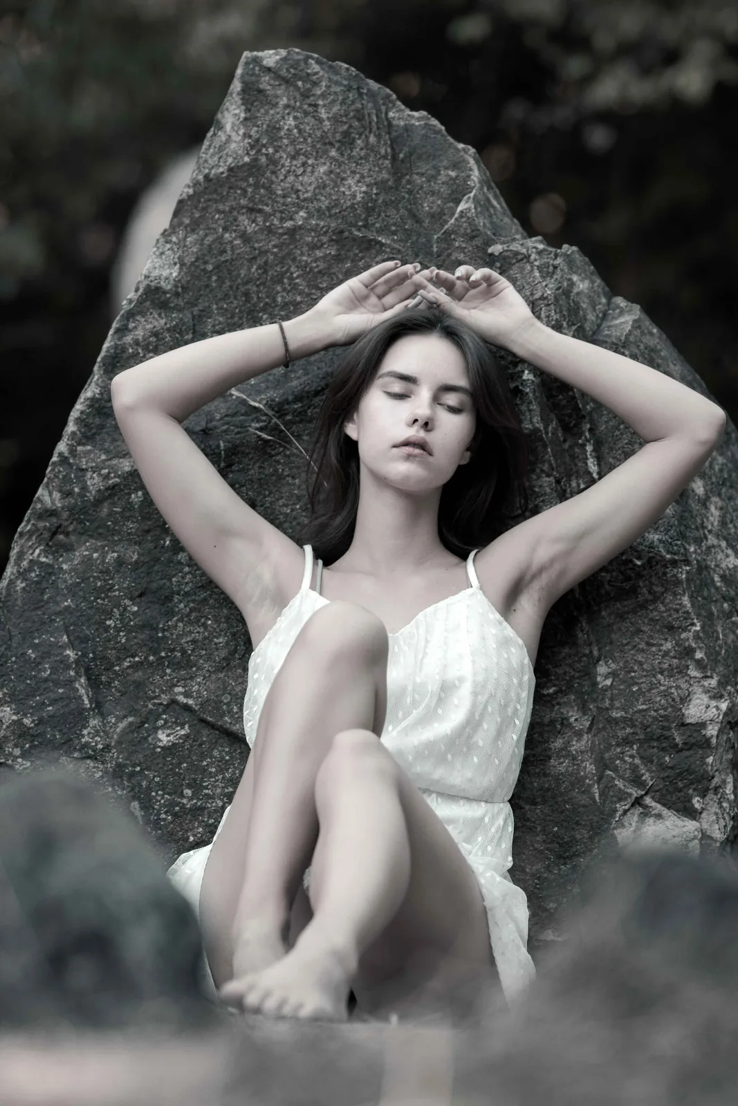 BETWEEN STONES – key image: Tiana in a light dress in front of a monolith of the Vienna stone circle