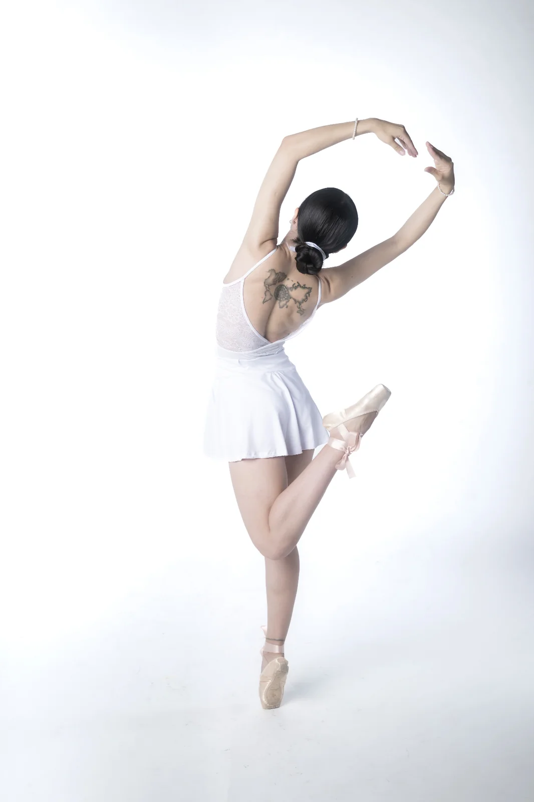 Fine art ballet portrait in a minimalist studio exploring movement, balance and sculptural elegance.