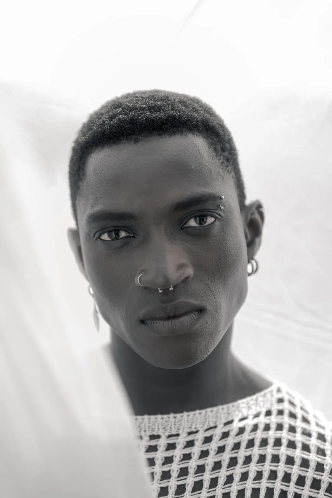 Modern high key editorial portrait of a male model in white, photographed by Peter Scholz for SCHOPHO