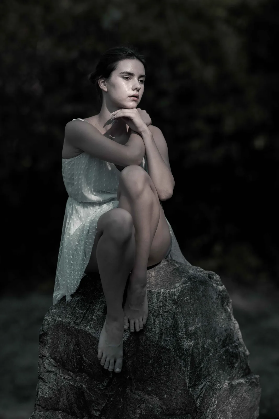 Tiana in a light dress seated on a stone of the Vienna stone circle