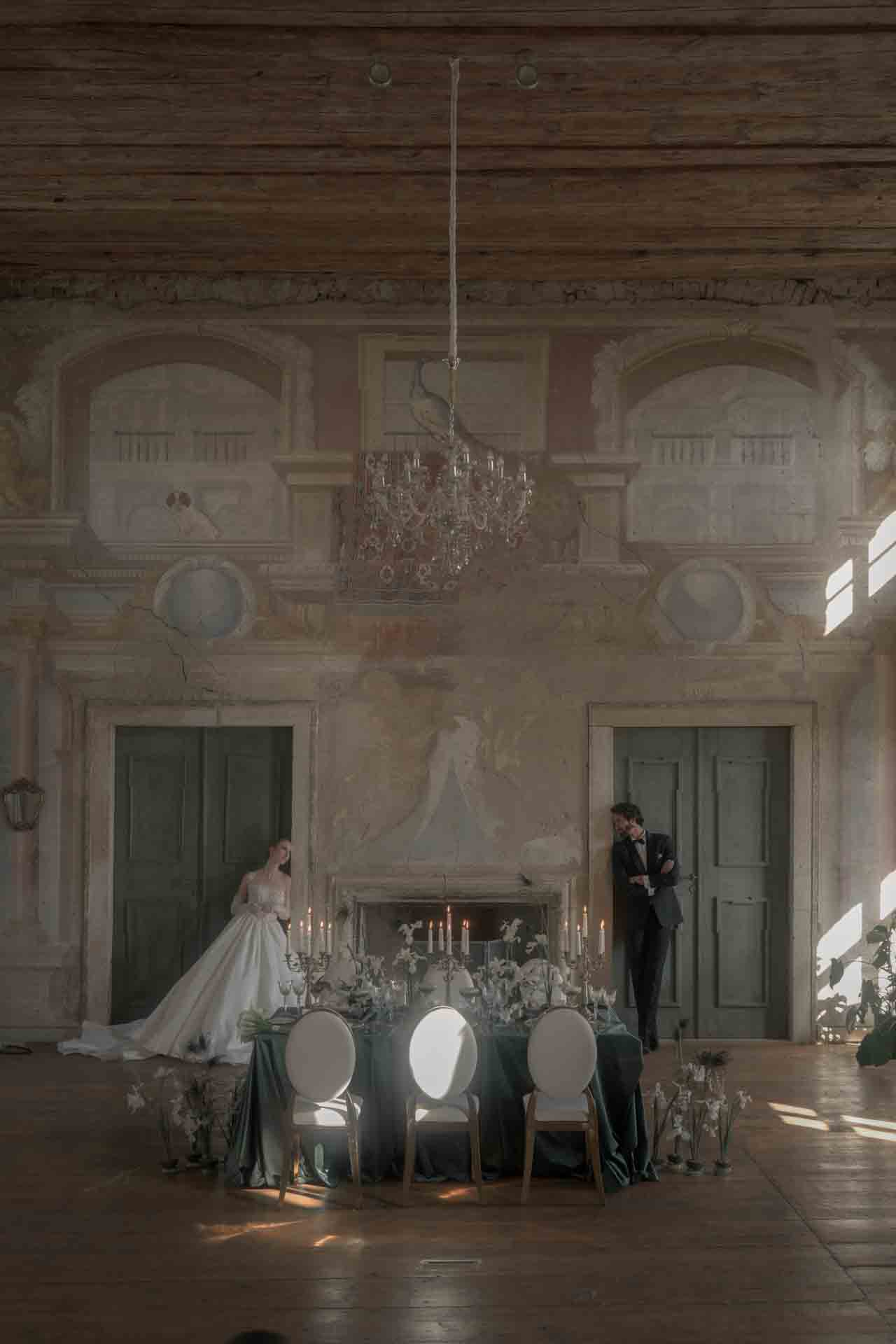 Braut und Bräutigam im Festsaal von Schloss Haggenberg mit barocken Fresken, Kristallluster und festlich gedeckter Tafel — Fine Art Wedding Photography Niederösterreich