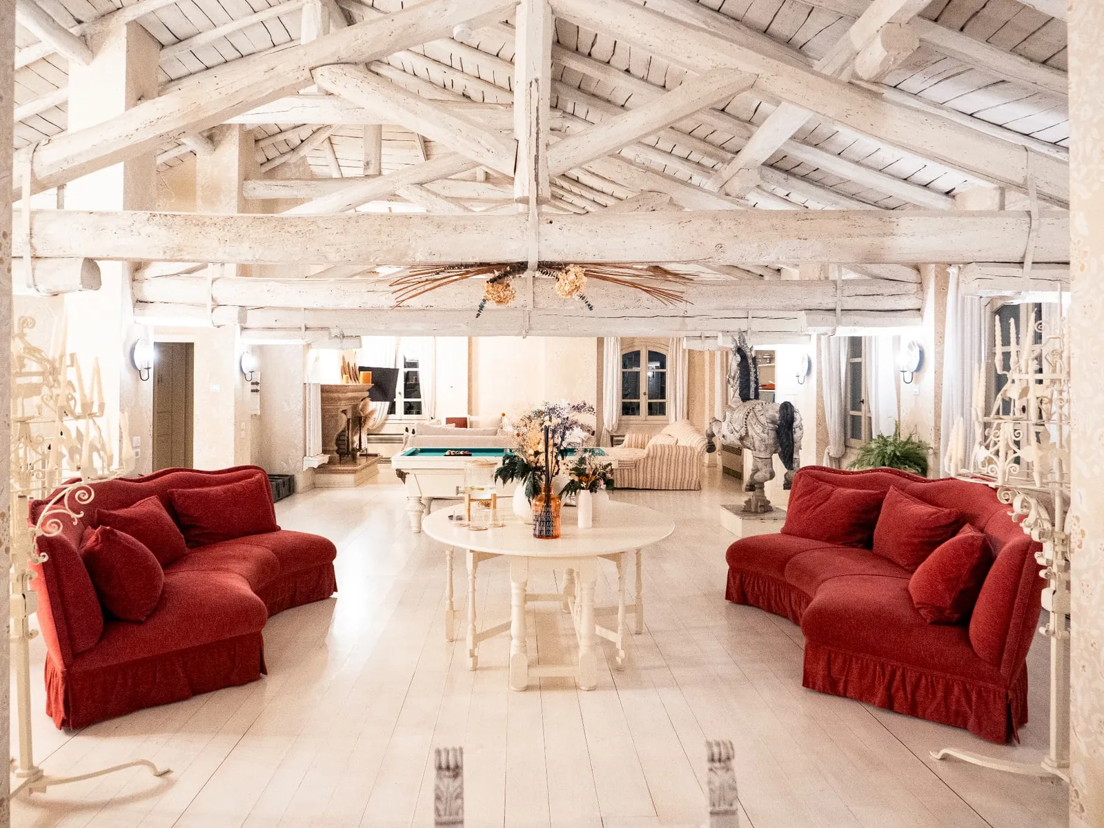 Living Room at the Elizabeth Country House with pale wooden beams and red sofas