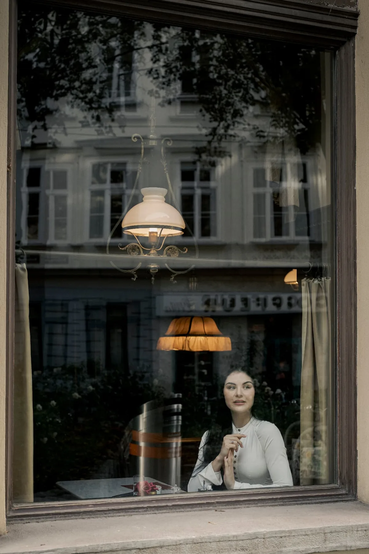 Izunia Motyl durch das Fenster des Café Sperl mit Spiegelungen der gegenüberliegenden Häuser