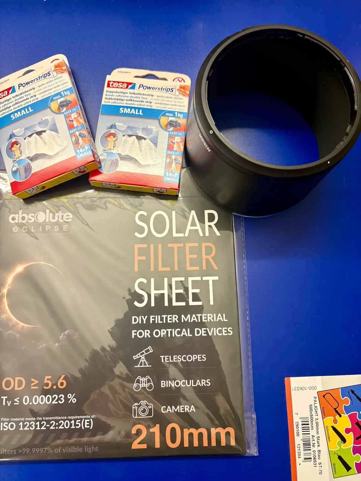 Materialübersicht: Absolute Eclipse Solar Filter Sheet, Tesa Powerstrips und originale Gegenlichtblende des NIKKOR Z 150–600 mm.