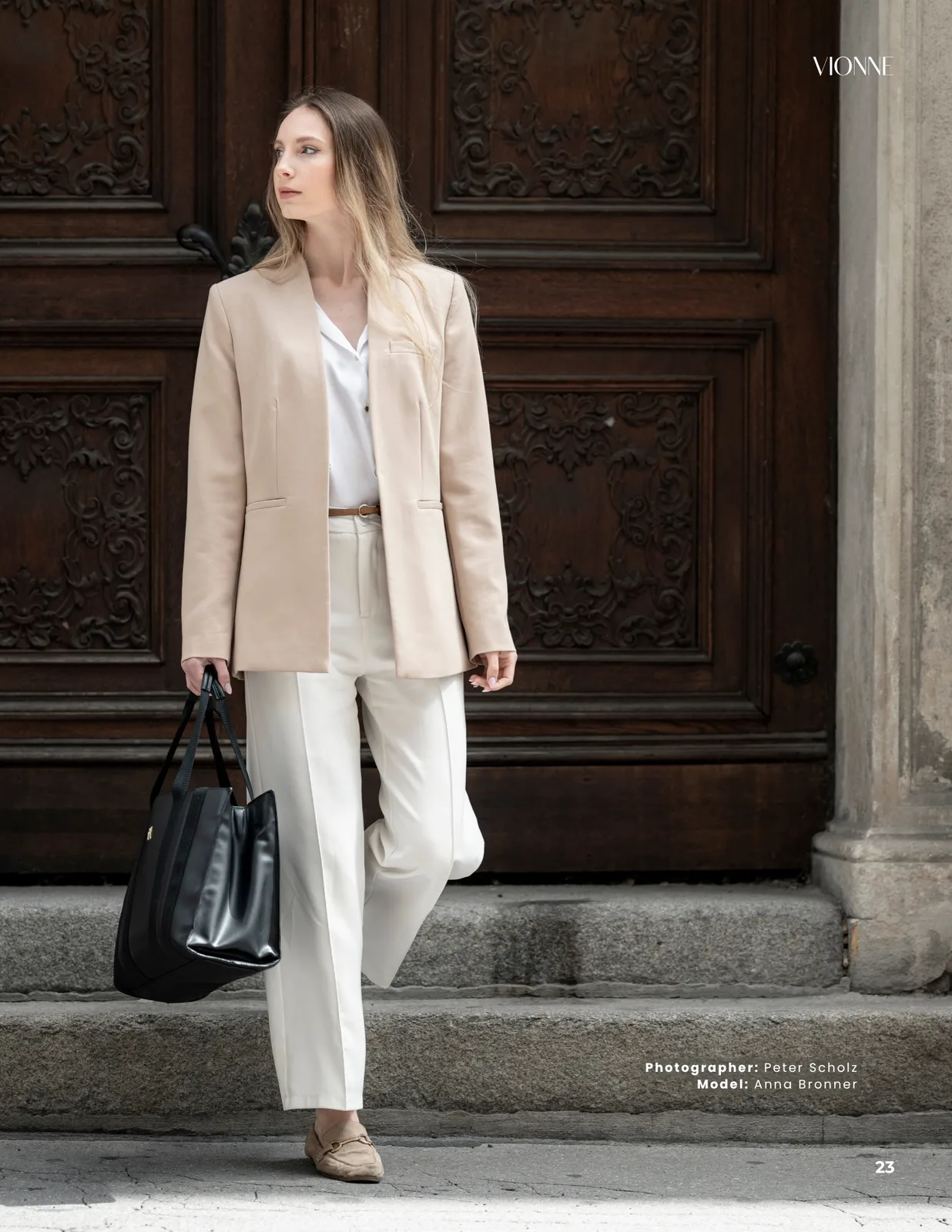 Page 23 closing the Hidden Vienna editorial in VIONNE Magazine Issue 16, Anna Bronner before a historic Vienna doorway, photographed by Peter Scholz