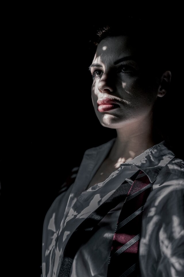 Modern fashion portrait of a woman in graphic light and shadow, photographed by Peter Scholz for SCHOPHO.