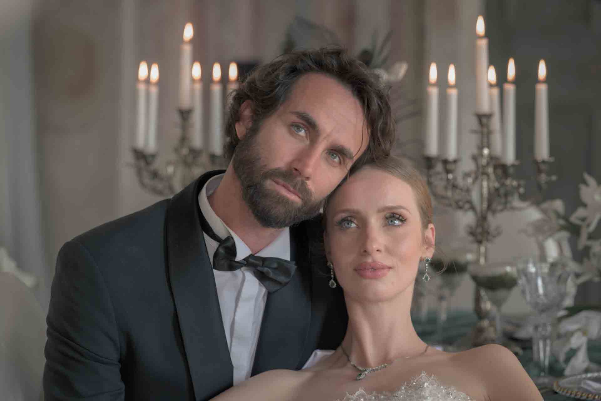 Intimes Porträt von Braut und Bräutigam vor Kerzenleuchtern im Festsaal von Schloss Haggenberg — editorial wedding photography Austria
