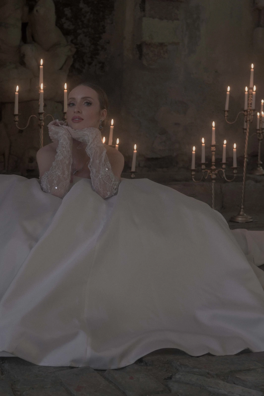 Bride in soft candlelight with lace gloves