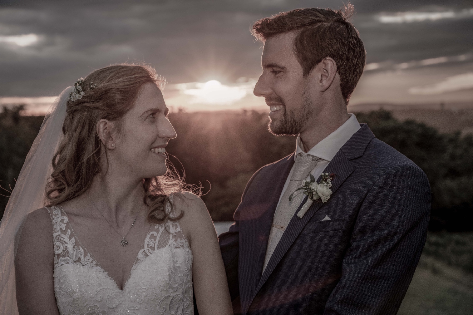 Bride and groom face to face in sunset light