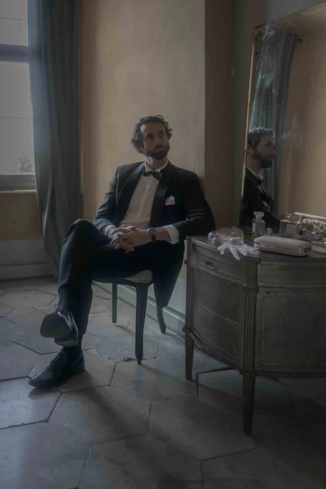 Groom taking a quiet moment by the window before the wedding ceremony at Schloss Haggenberg.
