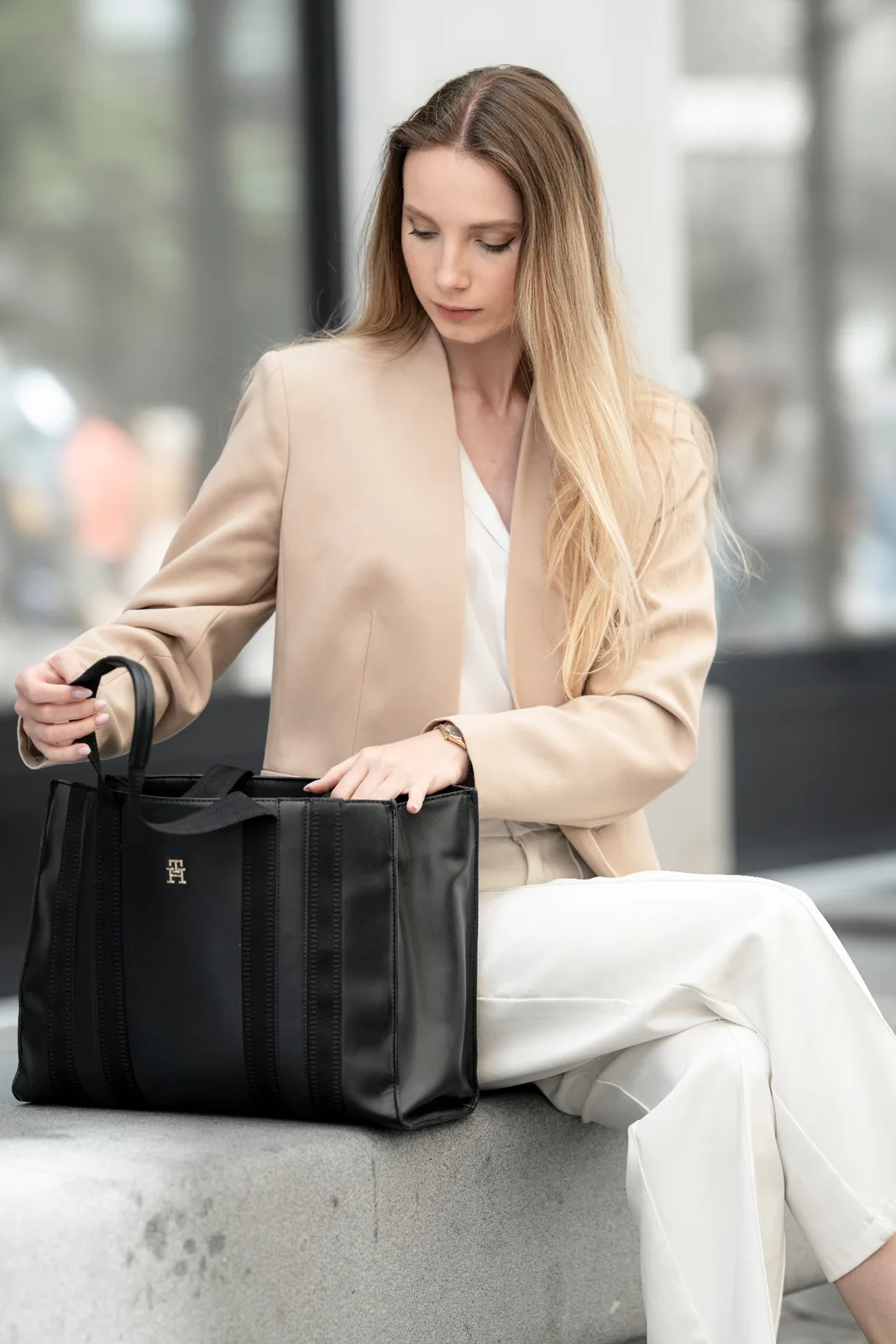 Editorial executive portrait of a female business leader in a beige blazer with a tote bag — modern personal branding photography in a Vienna urban setting