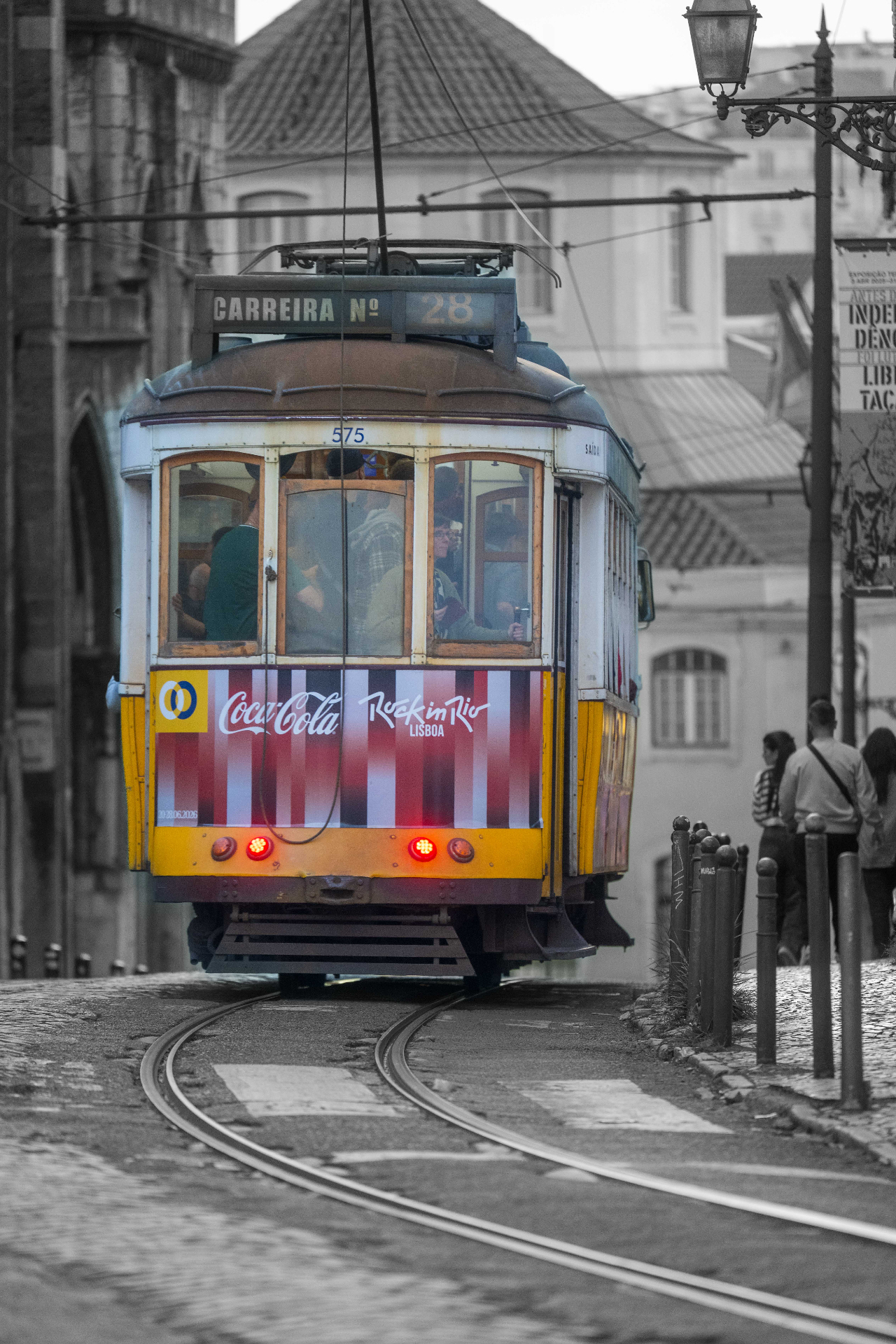 Yellow tram 28 ascending through Lisbon old town — selective color street photography by schopho