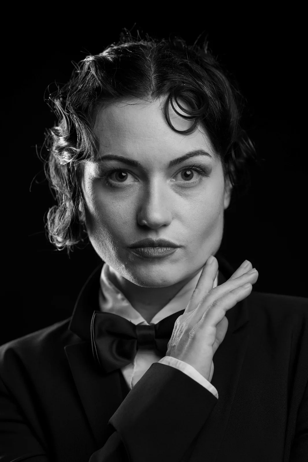 Editorial black and white portrait — woman in tailored tuxedo and bow tie, Marlene Dietrich inspired monochrome studio photography by Peter Scholz, Vienna