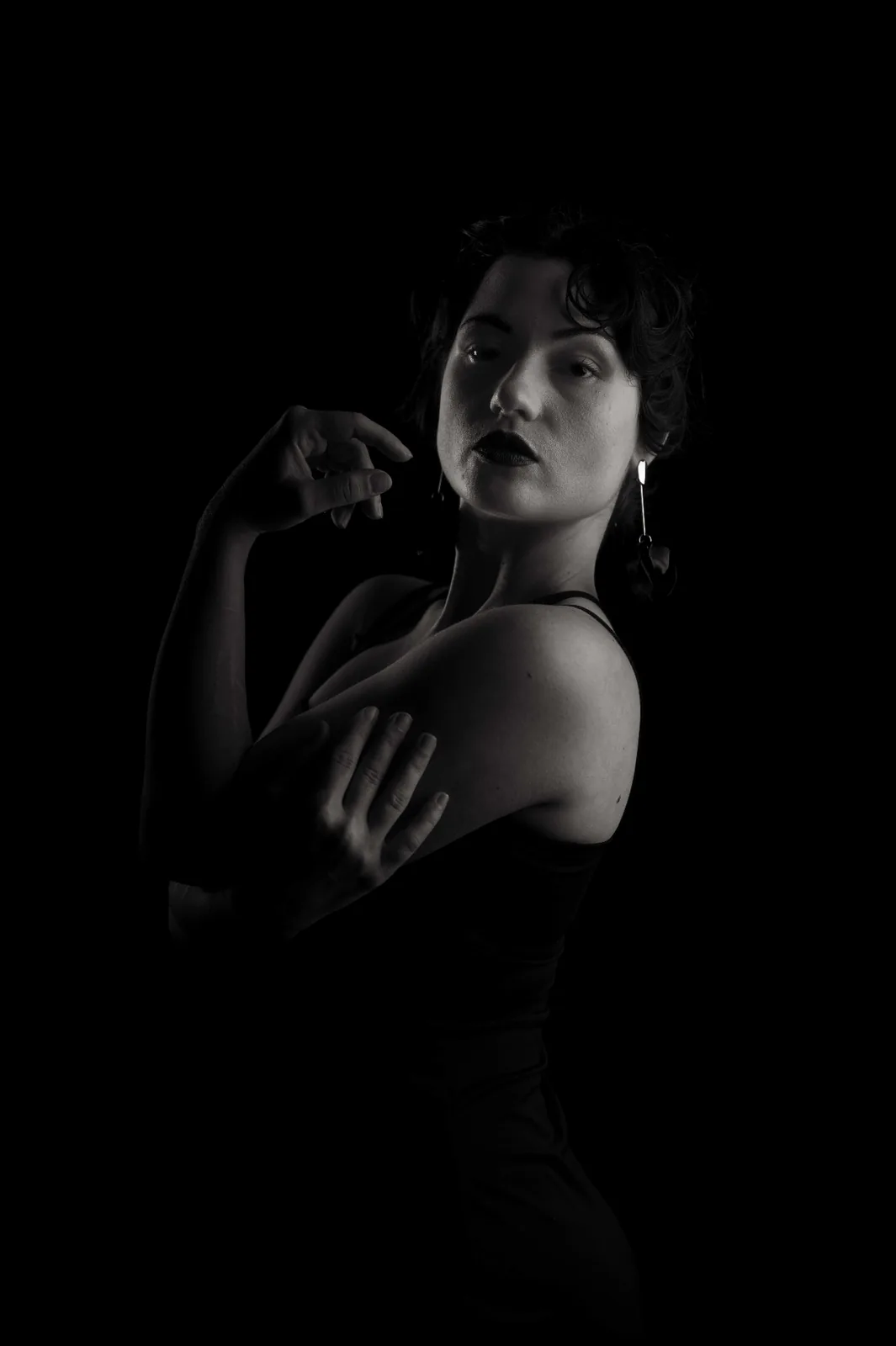 Low-key black and white studio portrait — woman in profile with sculpted shadow, from the Monochrome Presence editorial series by Peter Scholz